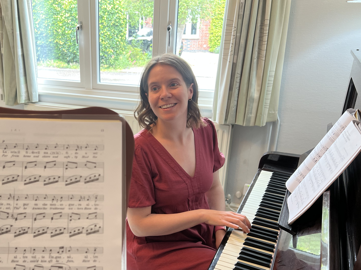 Kate Liggins sitting at the piano, teaching